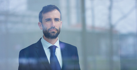 A businessman in a suit uses holography and augmented reality to see in 3D graphics financial economics in his office in a skyscraper. Concept: immersive technology, business, economy, futuristic	