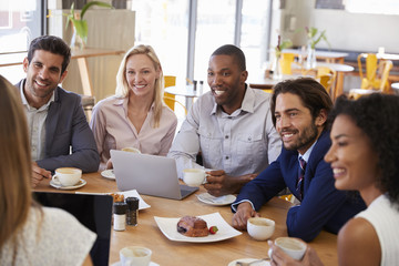 Group Of Businesspeople Having Meeting In Coffee Shop