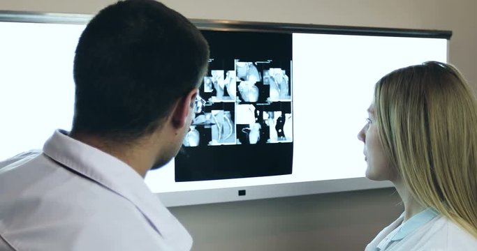 4K Doctors discussing and looking x-ray in a clinic or hospital.