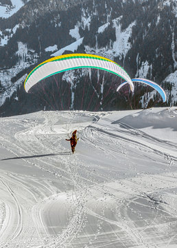The pilot begins flight on a paraplane with a mountain-skiing slope of Penken - Mayrhofen, Austria