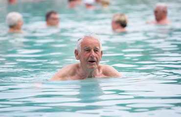 Senior man in swimming pool - obrazy, fototapety, plakaty