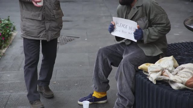 Homeless who feels cold receives hot breakfast from a gentle elderly man