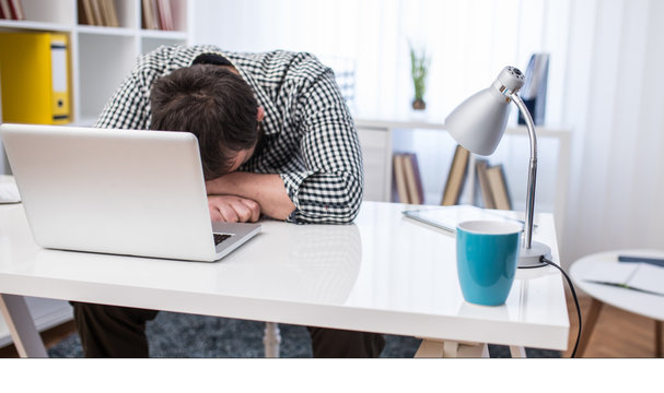 Young businessman sleeping on the laptop in office