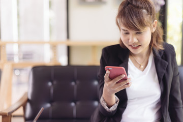 Asian female accountant or banker is busy working with laptop, smart phone and document in home office in selective focus. Concept : Busywork