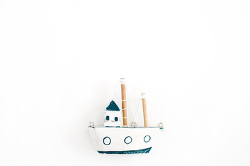 Fototapeta premium Wooden handmade toy boat on white background. Flat lay, top view
