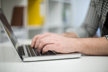 Cropped photo of a man's hands using laptop