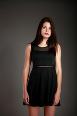 Fototapeta premium Portrait of beautiful brunette woman in black dress. Fashion photo