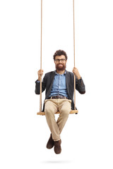 Bearded man sitting on a swing and looking at the camera