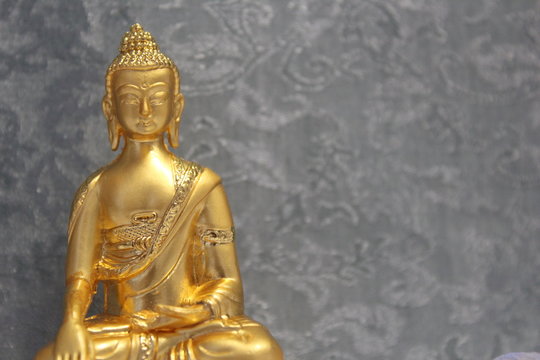 Gold Buddha Statue With a Blue Background