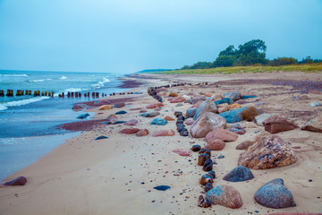 Sea shore, sand with pebbles. Deserted beach. Marine landscape with blue ocean and beautiful cloudy sky. 