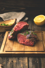 Raw beef tenderloin with greens and seasonings