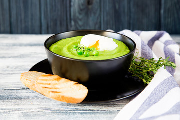 Homemade puree soup with green peas and micro greens. selective focus