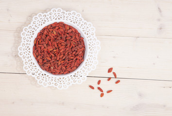 Obraz na płótnie Canvas Dried goji berries in white bowl on wooden background