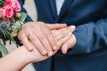 Obraz na płótnie Canvas Hands of newlyweds with wedding rings.