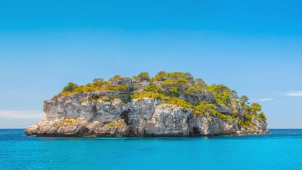 Deserted island in turquoise water of the sea.