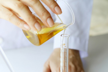 Beauty cosmetics sciences, Formulating and mixing skincare with herbal essence, Scientist pouring...