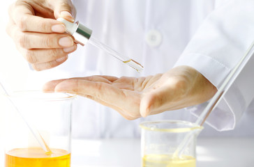 Fototapeta premium Beauty cosmetics sciences, Formulating and mixing skincare with herbal essence, Scientist testing a new organic beauty products on hand.