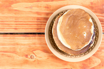 American pancakes on the plate over rustic wooden background table