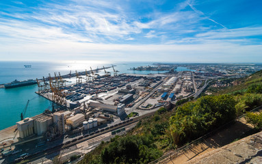 Sunshine on Balearic sea & Barcelona industrial shipping and rail ports on a blue-sky sunny day.  - 145578219