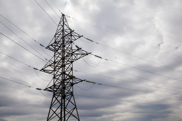 High voltage tower with rain clouds sky on background