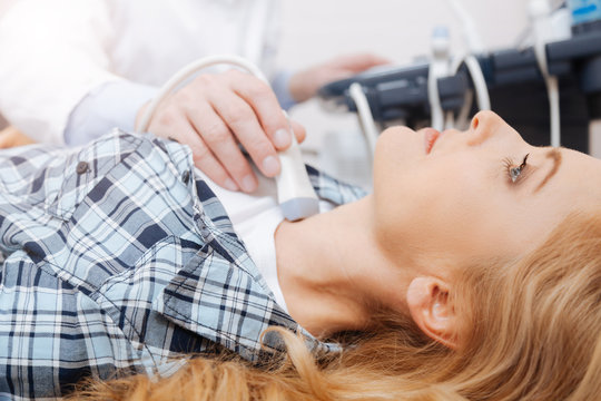Mature woman getting thyroid gland ultrasound in the hospital