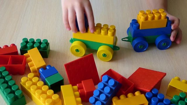 Kid construct toy vehicles from plastic bricks. Education in games, creativity learning with colorful blocks.
