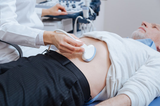Senior patient getting ultrasound scanning of abdomen in the clinic