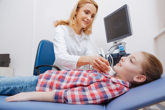 Optimistic young patient having ultrasound thyroid examination in the clinic