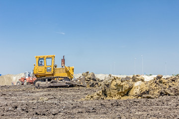 Obraz premium Heavy earthmover construction machine is moving earth at building site