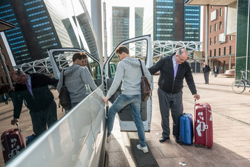 Taxi Driver With Luggage Picking Up Passenger At Airport