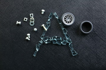 Plastic model of aluminum alloy wheel among broken tempered glass represent the damaged abstract meaning.