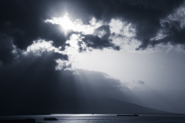 Dramatic sky with clouds and sunlight rays over sea - obrazy, fototapety, plakaty