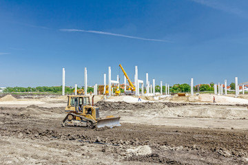 Heavy earthmover construction machine is moving earth at building site