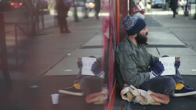 Sad homeless sitting  alone on the street begging alms