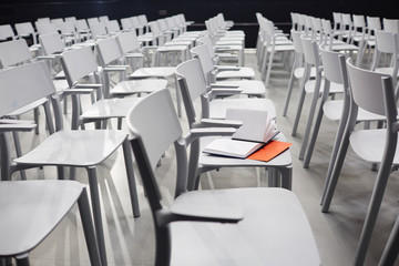 Open notebook on one of chairs in conference hall