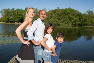 Fototapeta na wymiar mixed race racial family near the lake with blond and indian
