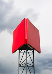 Blank red billboards on the pole made of metal rods. Place for visual advertisements commercials. Cloudy sky in the background