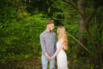 Beautiful Love story in the woods. Portrait of young stylish couple.