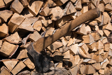 Old axe in log on a firewood background