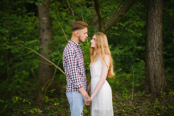 Fototapeta premium Beautiful Love story in the woods. Portrait of young stylish couple.