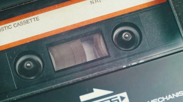 Audio Cassette in Tape Recorder Rewind. Vintage tape recorder Rewind the tape inserted therein. Close-Up. Tape with blank label in use sound recording in cassette player.