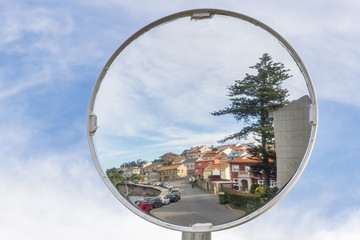 Village reflected on a traffic convex mirror