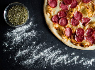 Tasty pizza with salami on dark background