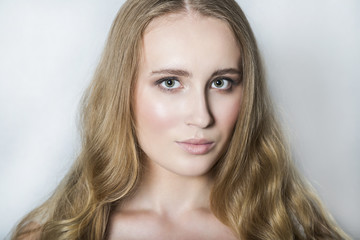 Naklejka premium Face of young blonde beautiful girl with makeup and long hair