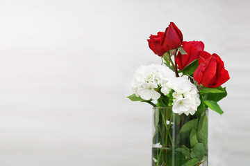 Cristal glass jar with some water and red roses and white flowers. Empty copy space for Editor's text.