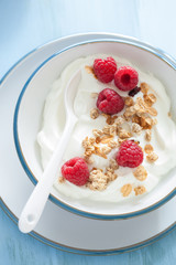 yogurt with granola and raspberry for healthy breakfast