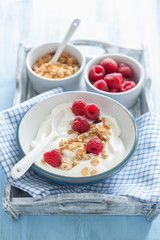 yogurt with granola and raspberry for healthy breakfast