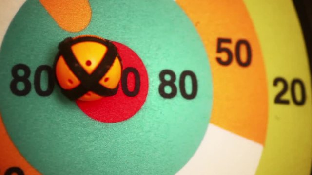 Close up hot of a target with a ball being thrown and hitting the center spot.