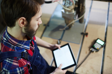 Young technician with touchpad at work