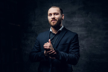 Bearded male with crossed arms, dressed in a blue jacket over grey vignette background.